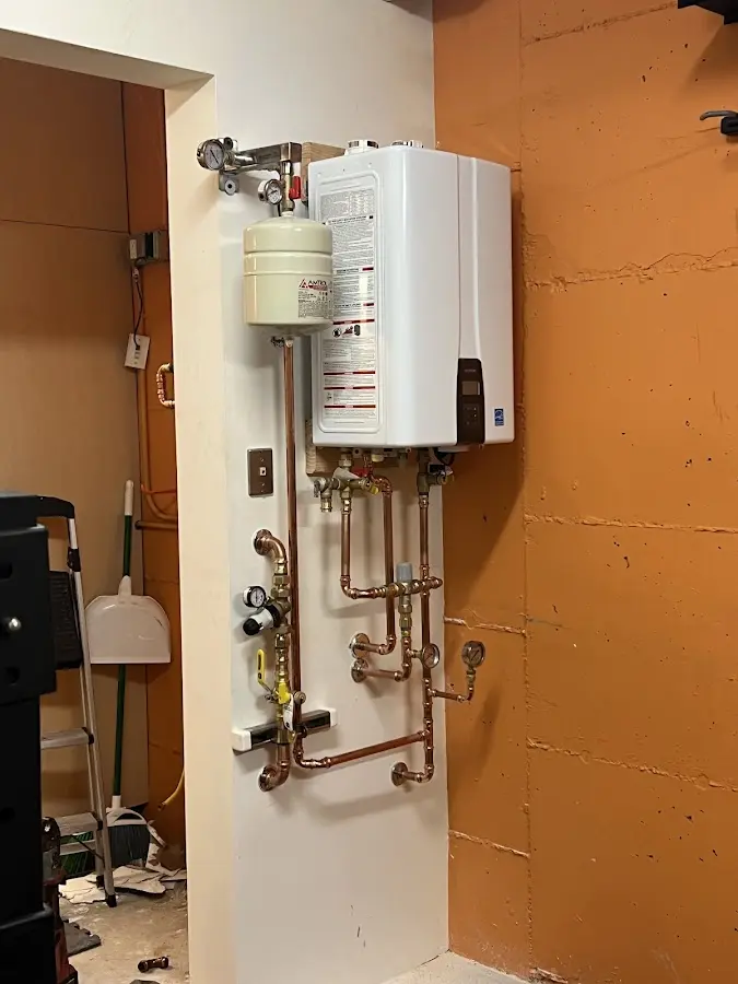 Plumbing technician inspecting water heater connections in Great Neck Estates
